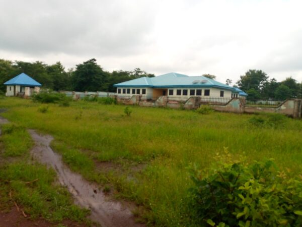 Establishment shot of Awulema Hospital depicts isolation from the village